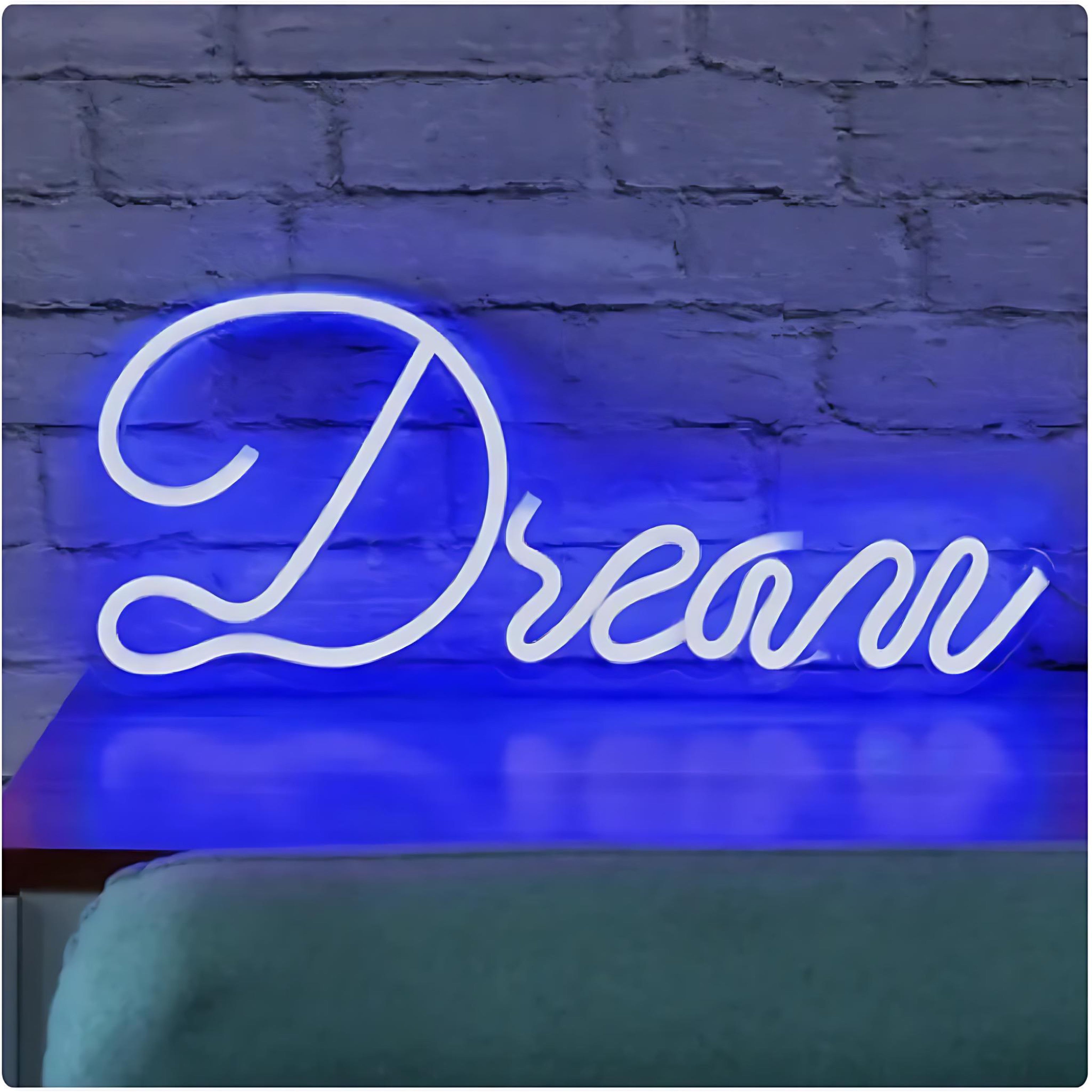 Blue neon LED sign spelling “Dream” against brick wall