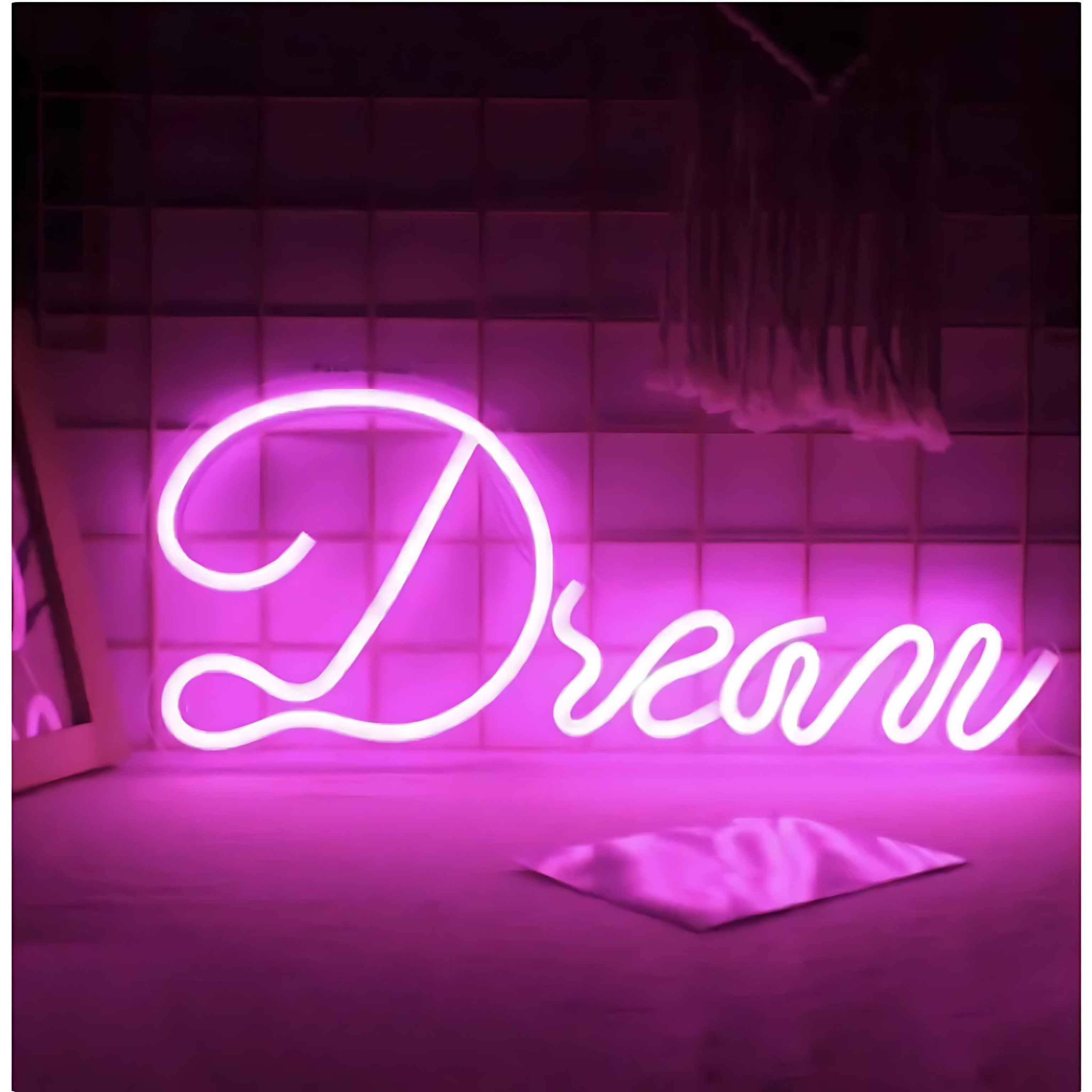 Pink neon light spelling the word “Dream” on dark background