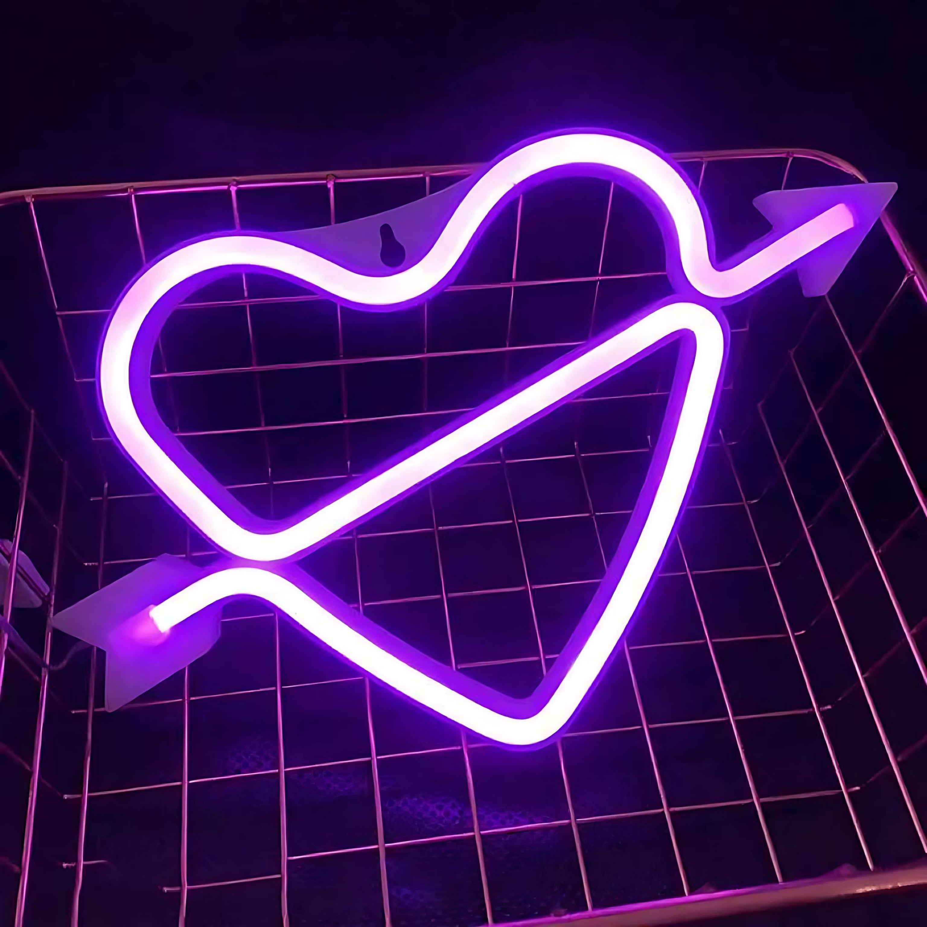 Pink neon light shaped like a heart with an arrow