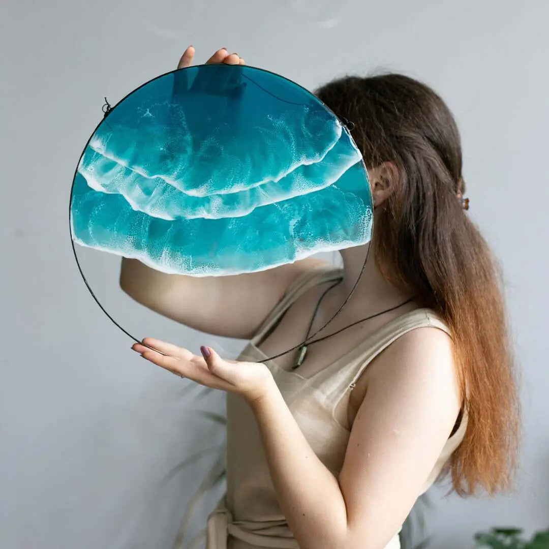 Round acrylic wall art with ocean wave design, held by woman in neutral dress – calming coastal décor piece. 🌊
