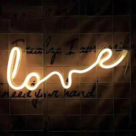 Warm white neon light sign with the word love in script