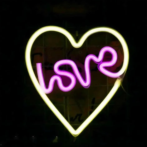 Yellow neon light shaped like a heart with the word love inside