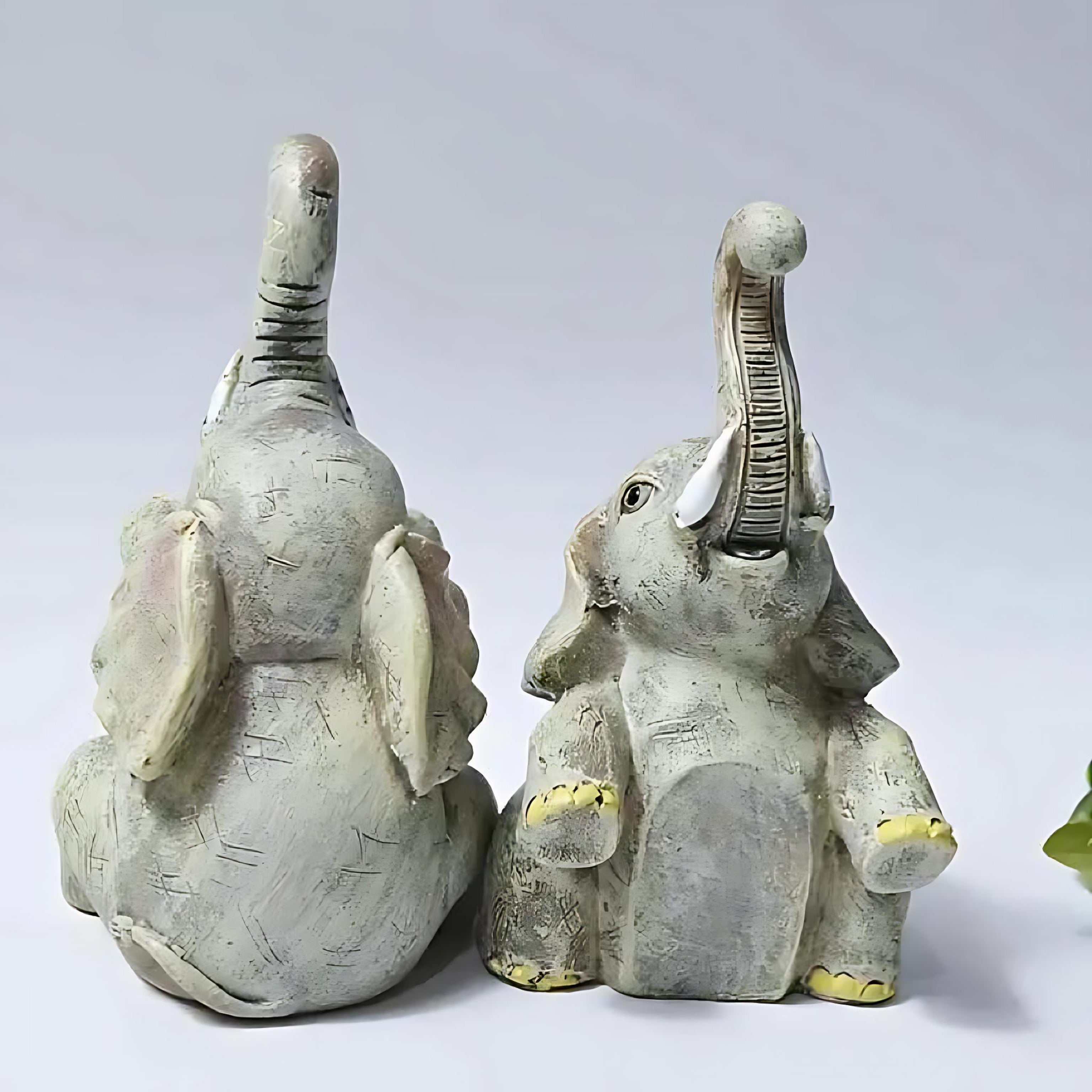 Back view of the sitting resin elephant figurine set with raised trunks and rustic detailing.