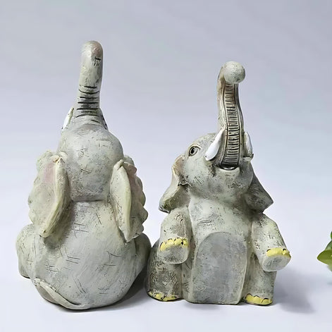 Back view of the sitting resin elephant figurine set with raised trunks and rustic detailing.